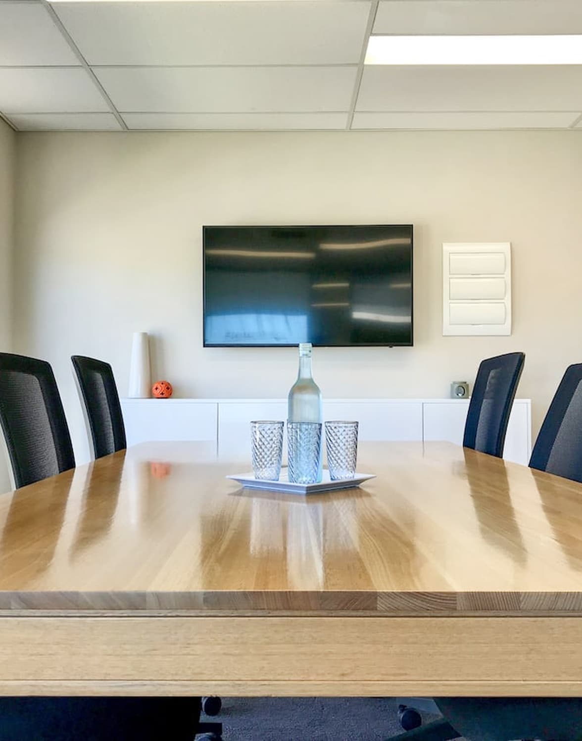 Modern conference room with table and TV.