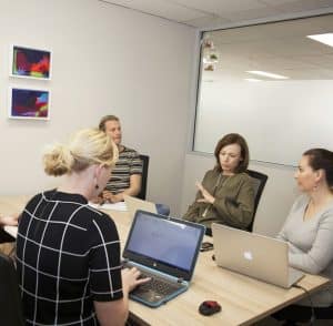 Team meeting in office with laptops.