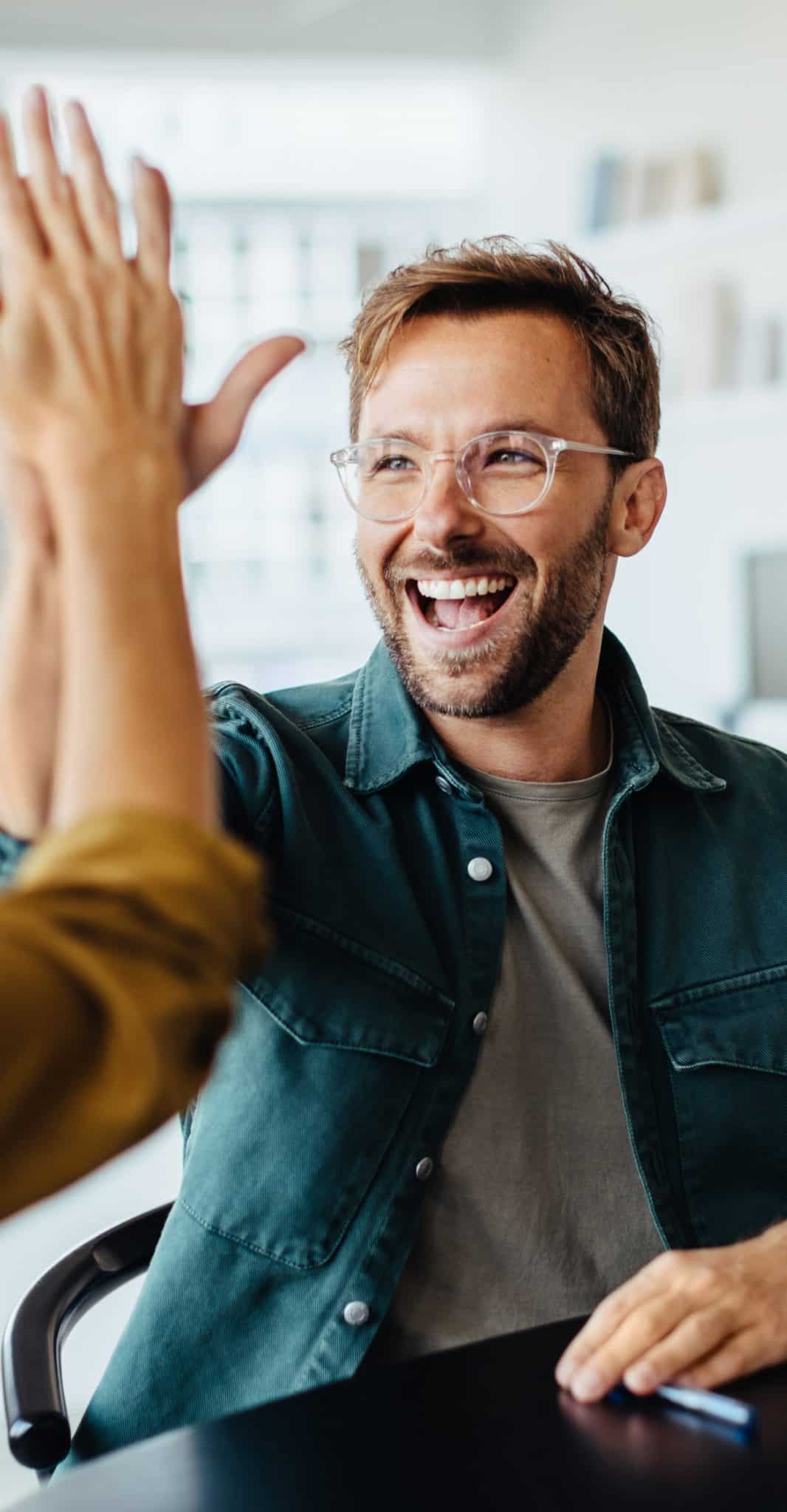 Smiling person giving a high five.